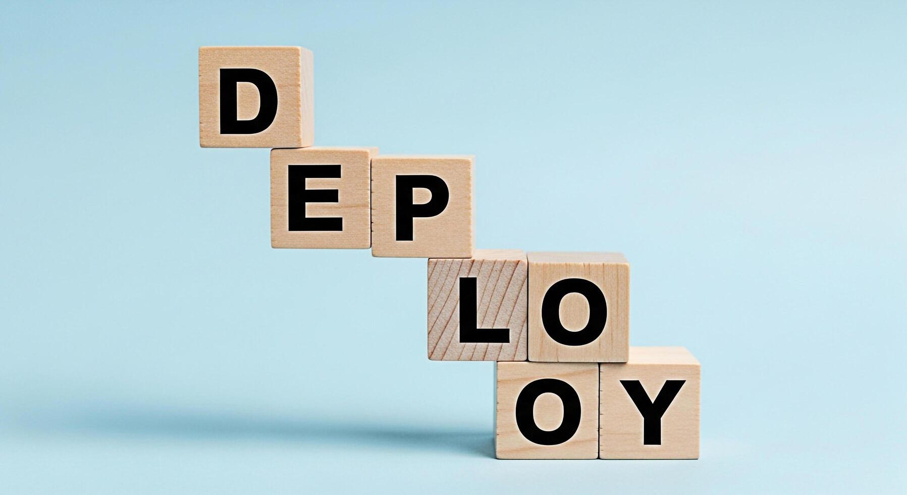 Wooden blocks spelling DEPLOY stacked on a light blue background representing a software development process and conveying a sense of progress and systematic implementation photo