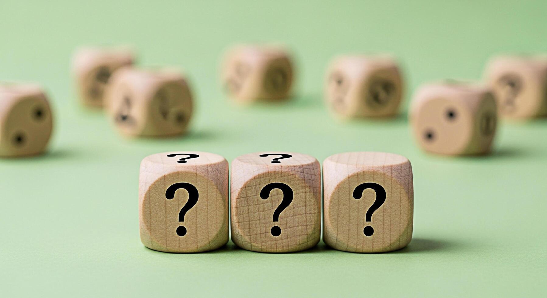 Wooden dice displaying question marks on a green surface representing uncertainty and the need for answers in a playful and inquisitive setting conveying a sense of mystery and exploration photo