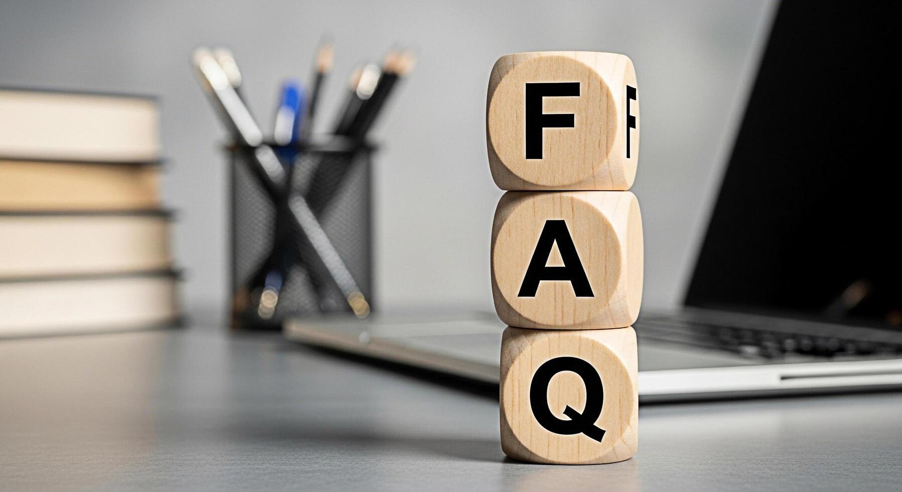 Wooden FAQ blocks stacked on a desk in a modern office setting representing frequently asked questions and providing information and support to customers with a clear and concise message photo