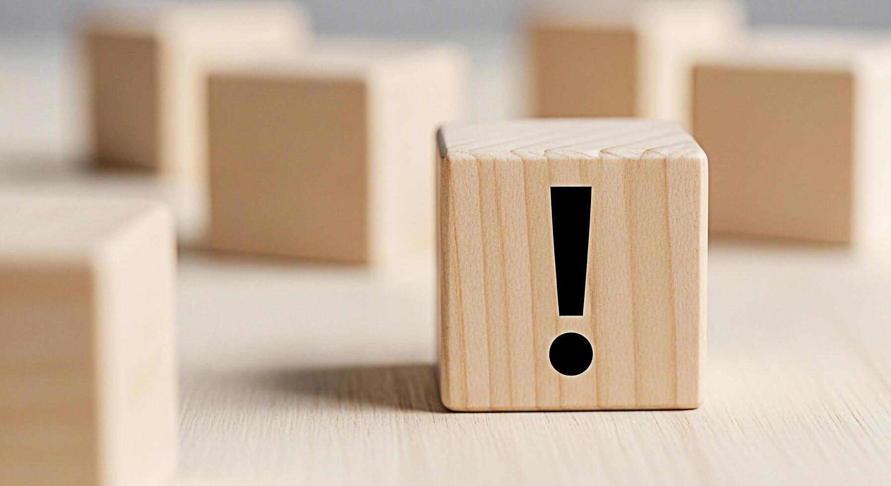 Wooden block displaying an exclamation mark on a wooden surface symbolizing attention and warning creating a sense of urgency and importance in a minimalist and clean environment photo