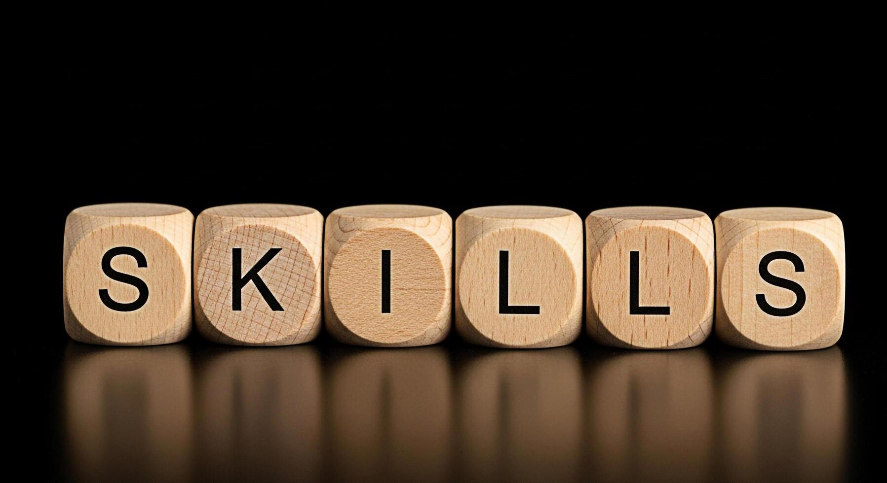 Wooden blocks spelling SKILLS on a reflective surface against a black background symbolizing competence and expertise in a professional environment conveying a message of capability and proficiency photo