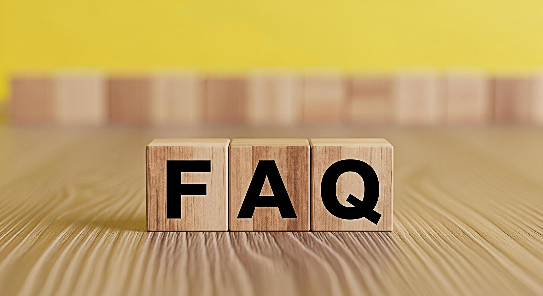 FAQ letters on wooden blocks displayed on a wooden table against a yellow background representing frequently asked questions and providing information and support with a clear and concise message photo