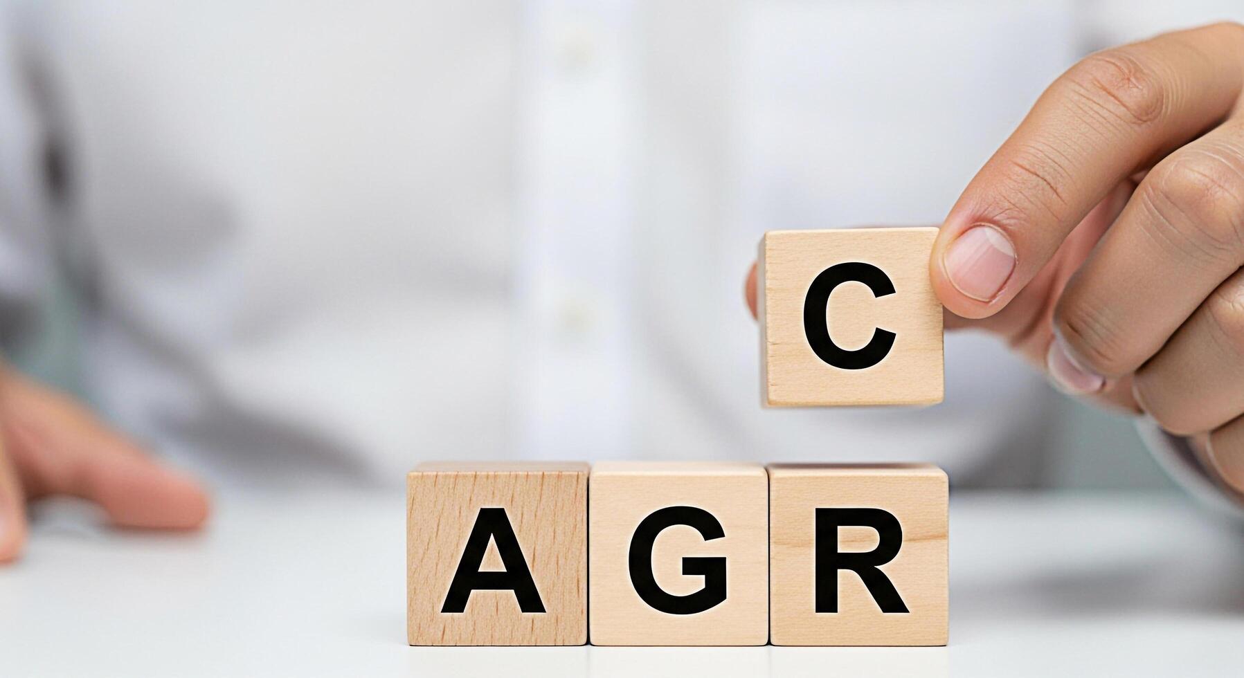 Person arranging wooden blocks spelling ACR and adding a C block on a white table symbolizing the concept of achieving accuracy and precision in business and data analysis photo