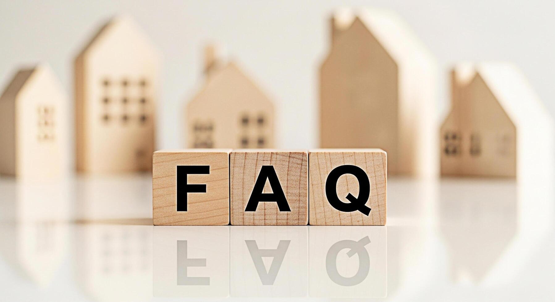 Wooden blocks displaying FAQ in a bright minimalist setting with blurred house models representing frequently asked questions about real estate and creating a sense of clarity and information photo