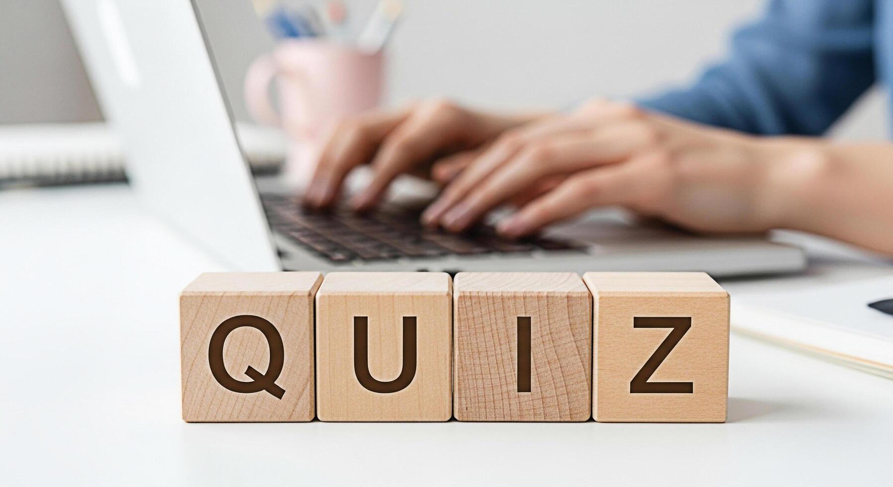 Person typing on a laptop with wooden blocks spelling QUIZ on a white desk creating a learning and assessment environment emphasizing knowledge testing and educational engagement photo