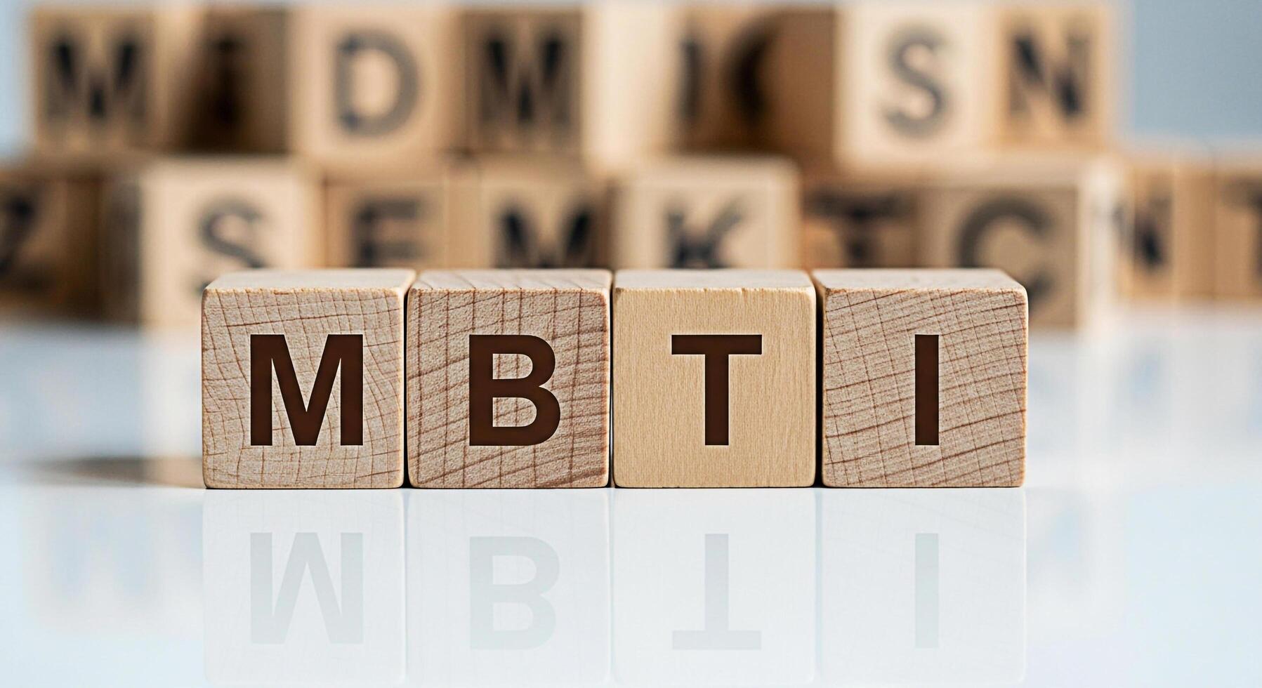 Wooden blocks spelling out MBTI on a white reflective surface representing personality assessment and psychological types in a clean professional setting conveying concepts of selfawareness and career photo