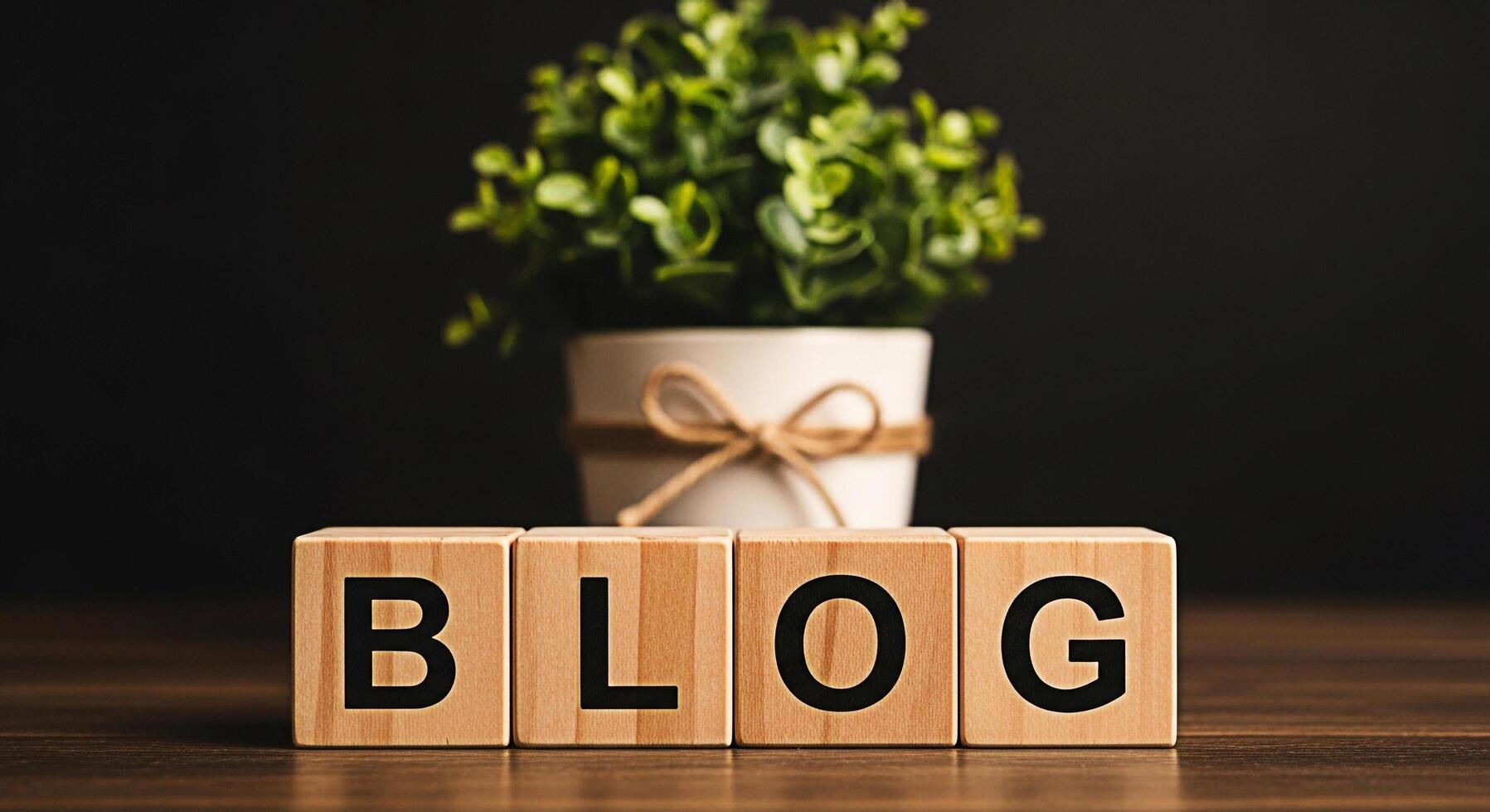 Wooden blocks spelling BLOG on a wooden table with a potted plant in the background creating a warm and inviting atmosphere for content creation and online engagement photo