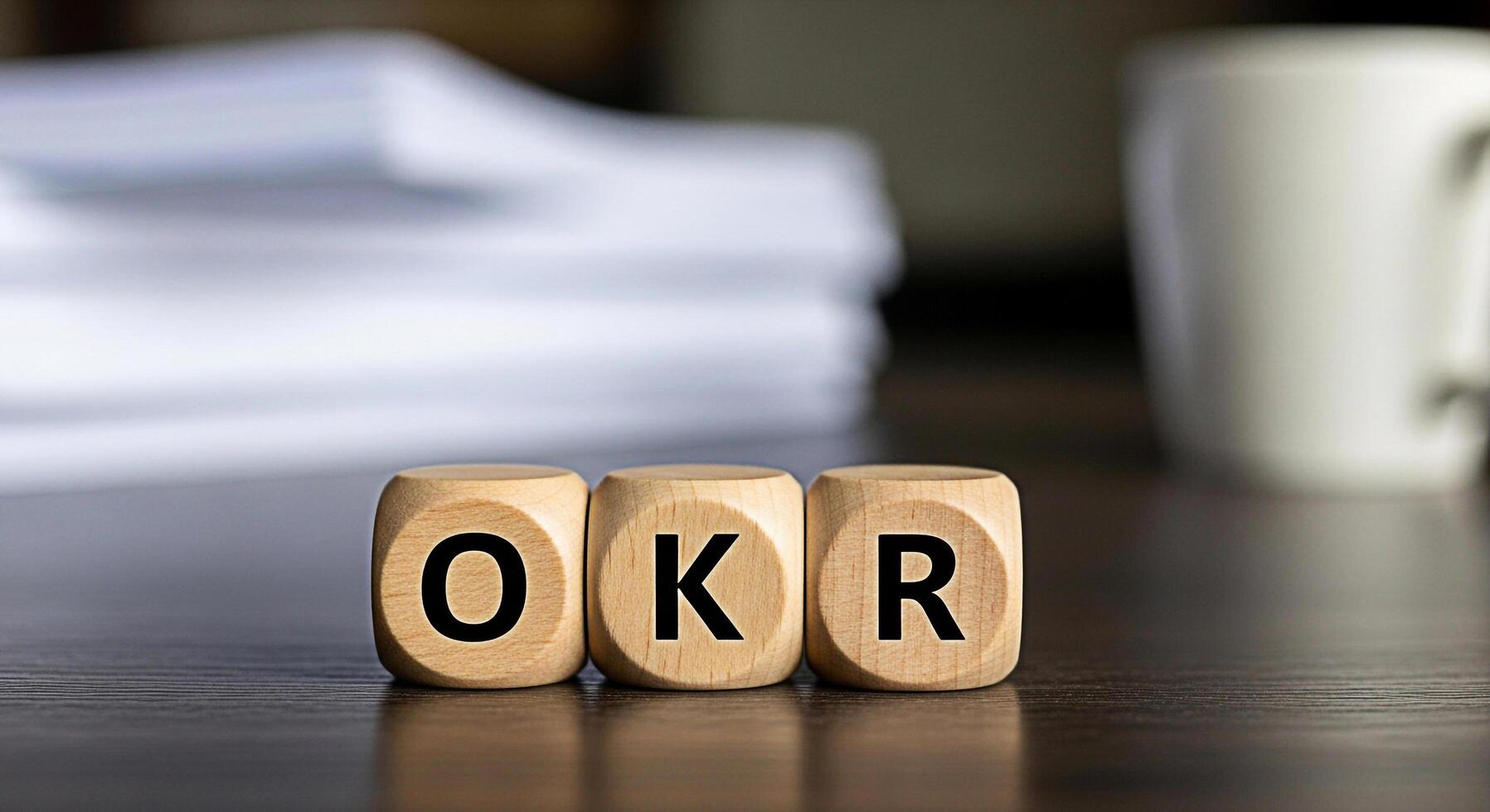 Wooden blocks displaying OKR on a dark wooden table in a bright office symbolizing objectives and key results goal setting and strategic planning for business success and performance management photo