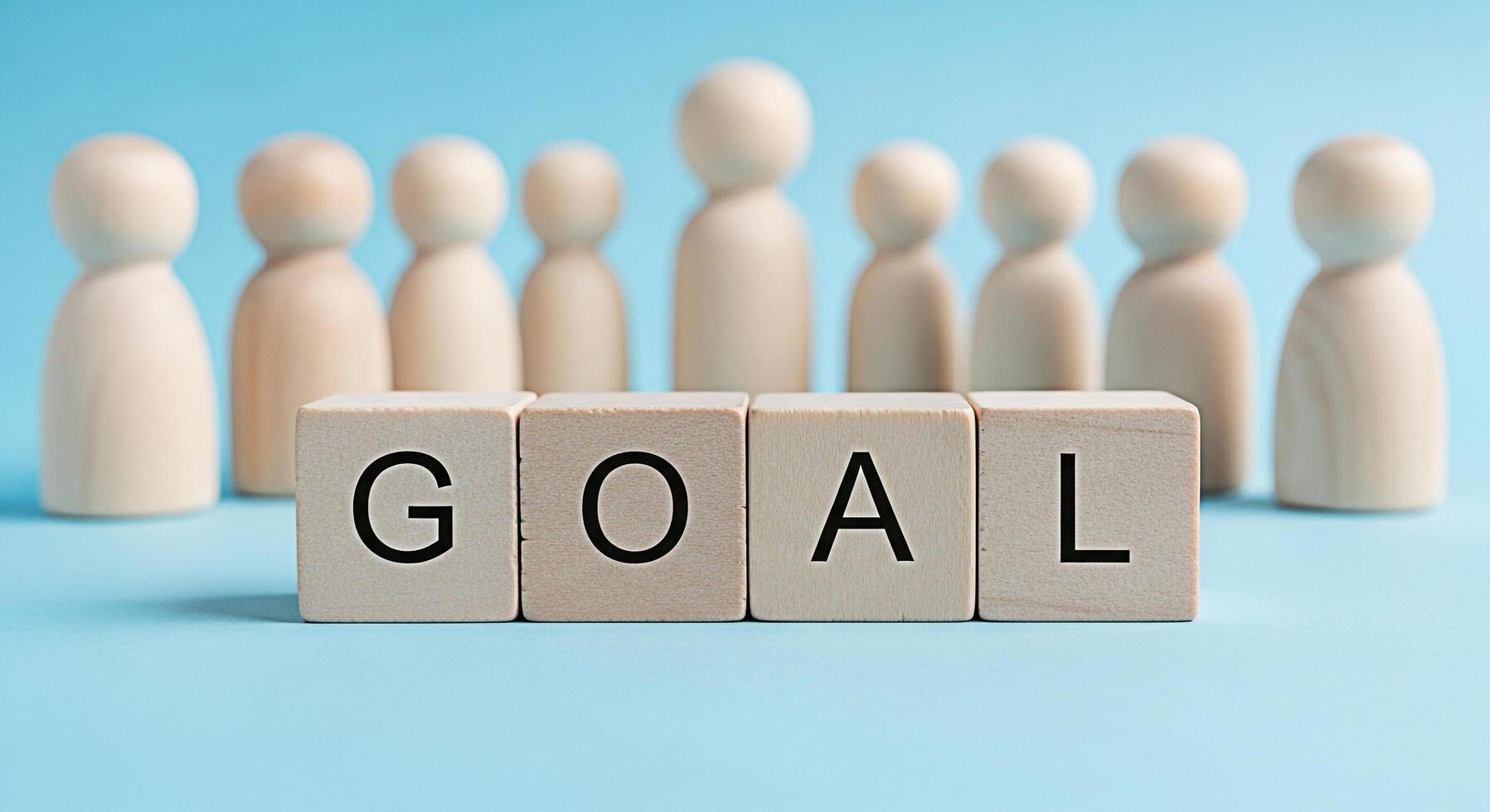 Wooden figures standing behind blocks spelling GOAL on a blue surface representing teamwork and focus on achieving objectives in a collaborative and supportive environment fostering a sense of purpose photo