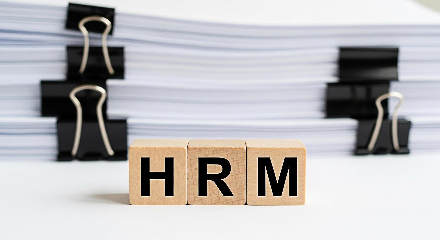 HRM wooden blocks standing out in a pile of documents representing human resource management in a corporate environment symbolizing organization and efficiency in business processes photo