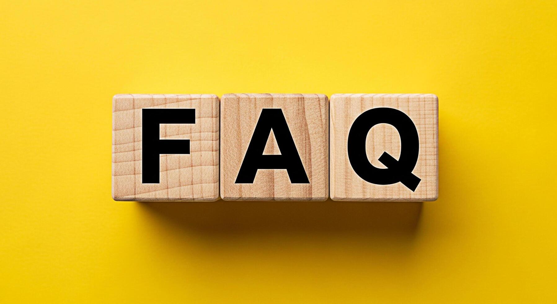 Wooden blocks spelling FAQ on a vibrant yellow background representing frequently asked questions and providing clarity and support creating a sense of helpfulness and information access photo