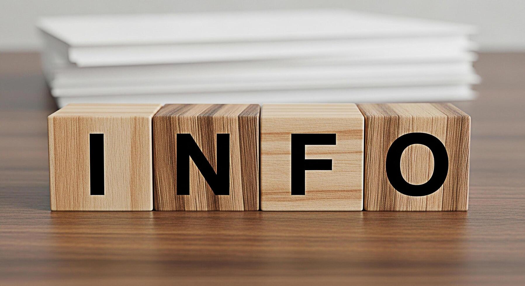 Wooden blocks spelling INFO on a wooden desk with a stack of papers in the background representing information knowledge and resources in a professional and informative setting photo