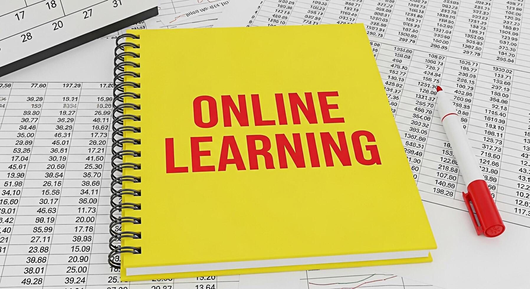 Bright yellow notebook displaying Online Learning on a financial spreadsheet with a red marker symbolizing accessible education and the integration of technology in modern financial education photo