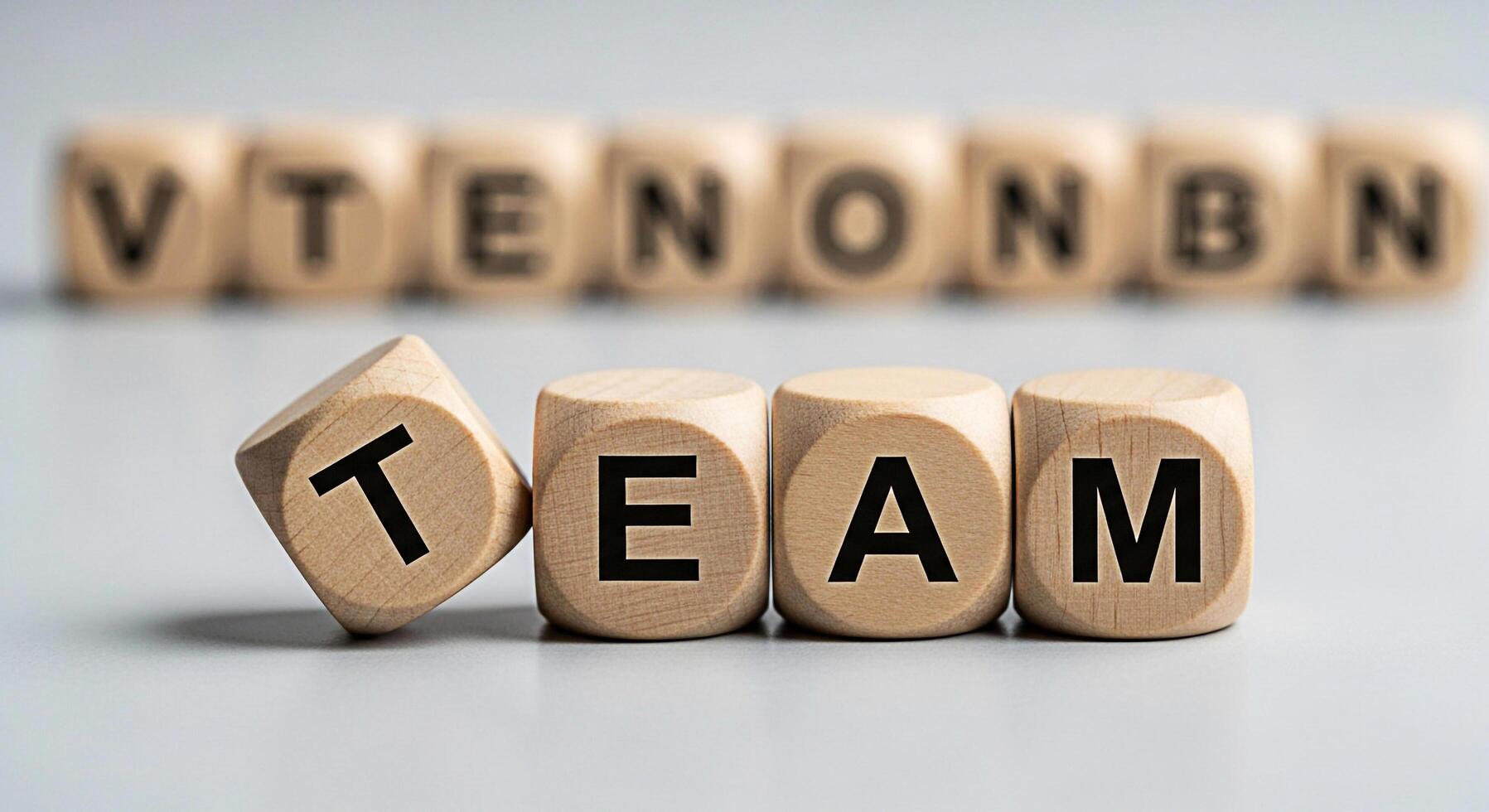 Wooden blocks spelling TEAM and VTEONBN on a gray surface symbolizing collaboration unity and the importance of teamwork in achieving business goals and fostering a supportive work environment photo