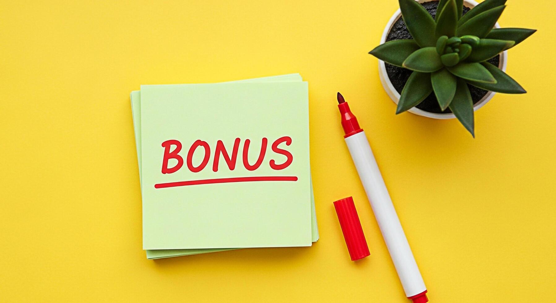 Bright yellow background featuring a stack of sticky notes displaying the word BONUS in red marker accompanied by a succulent plant and marker conveying a positive and rewarding message photo