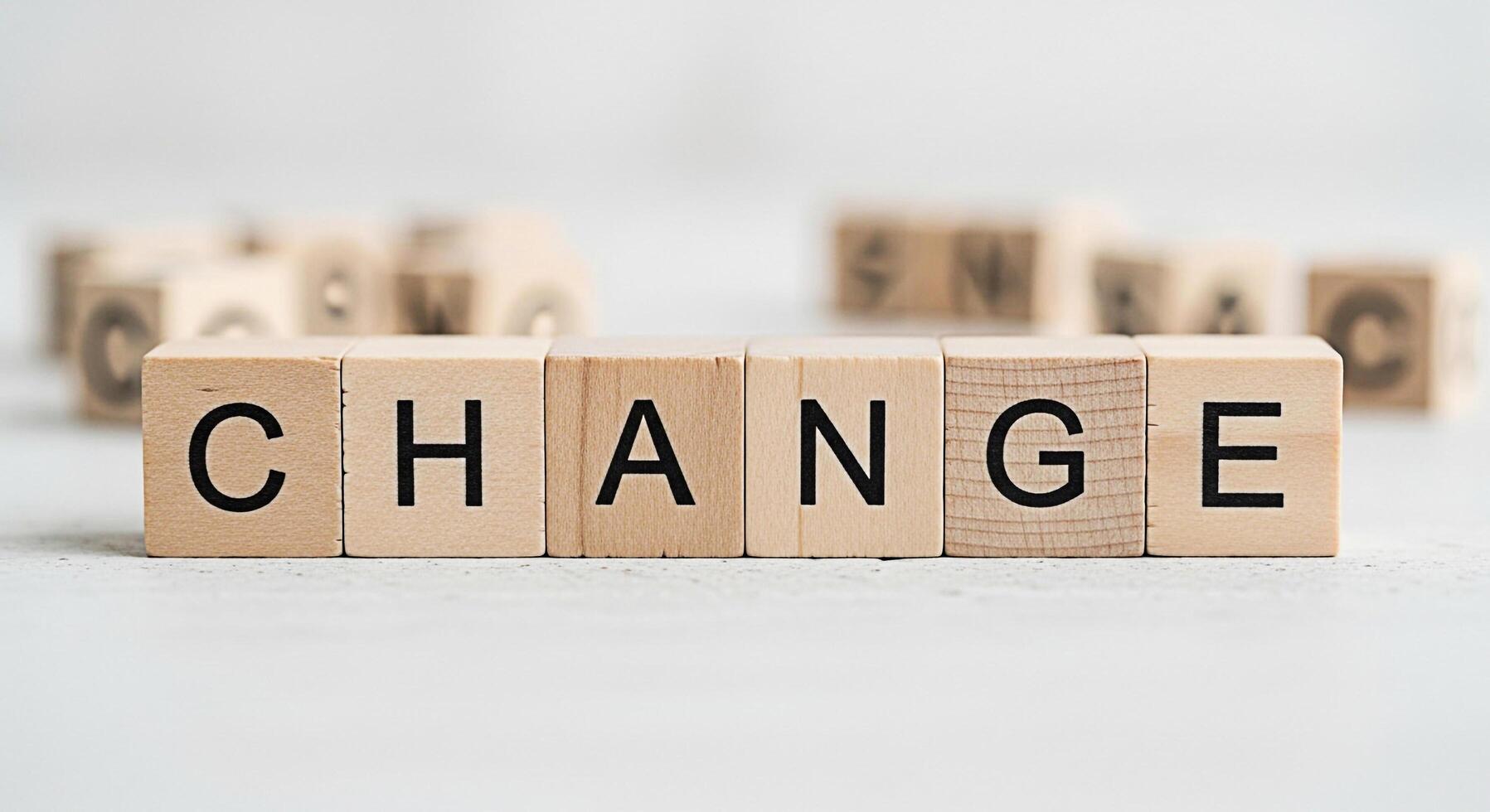 Wooden blocks spelling CHANGE on a white surface symbolizing transformation and progress set against a blurred background of other blocks creating a sense of opportunity and new beginnings in a bright photo