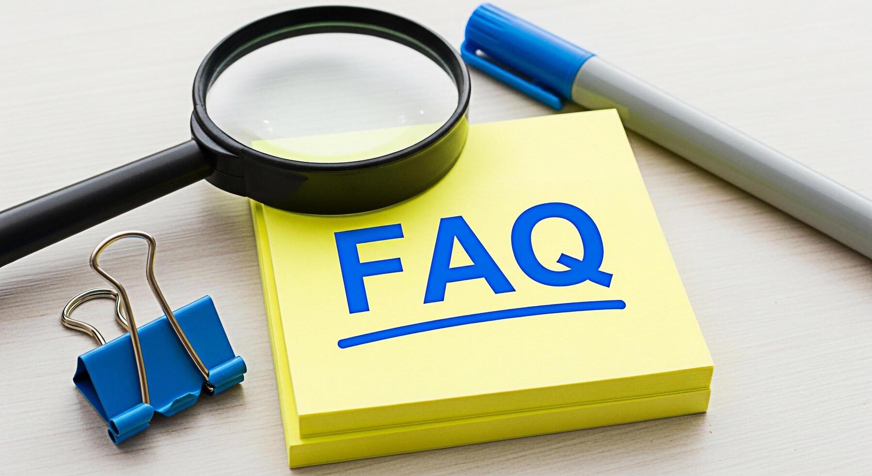 Closeup of a stack of yellow sticky notes displaying FAQ under a magnifying glass on a bright wooden desk symbolizing information seeking and problemsolving in a business environment photo