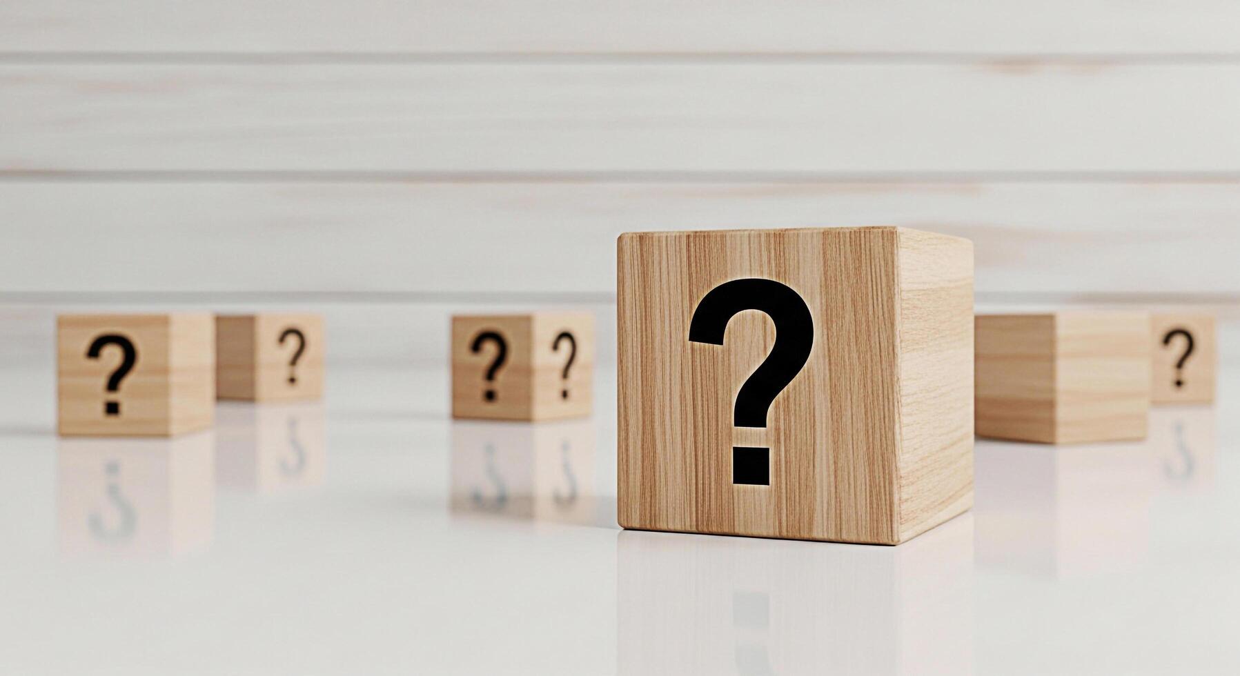 Wooden blocks displaying question marks on a reflective surface against a white wood panel background symbolizing uncertainty inquiry and the search for answers in a clean and minimalist setting photo
