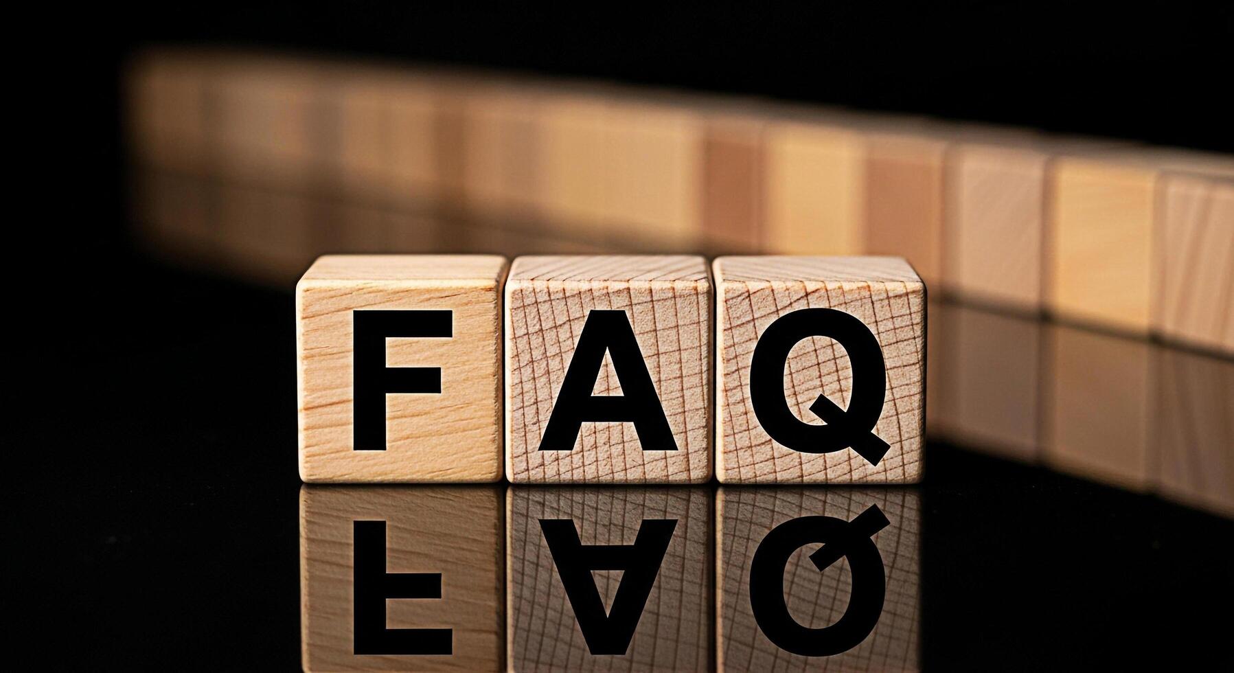 Wooden blocks spelling FAQ on a reflective black surface representing frequently asked questions and information resources creating a sense of clarity and helpfulness in a professional setting photo