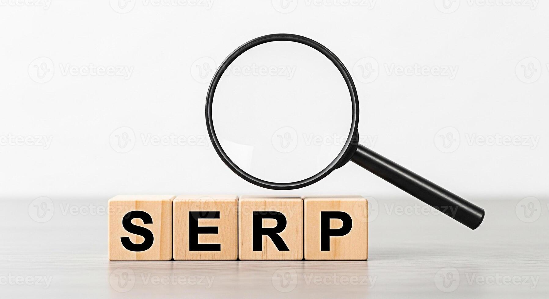Magnifying glass examining wooden blocks spelling SERP on a bright table symbolizing search engine results page optimization and the importance of online visibility for business success photo
