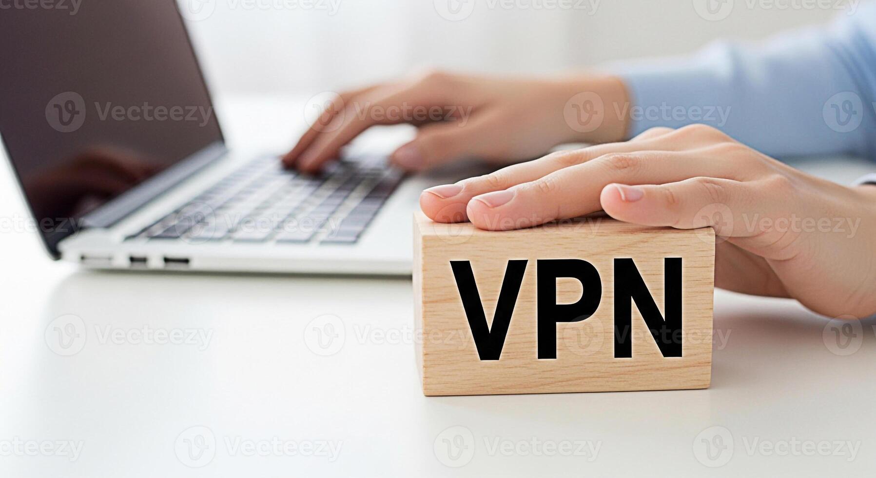 Person using a laptop computer with a VPN wooden block on a white desk emphasizing secure online browsing and data protection in a modern workspace conveying a sense of digital safety and privacy photo