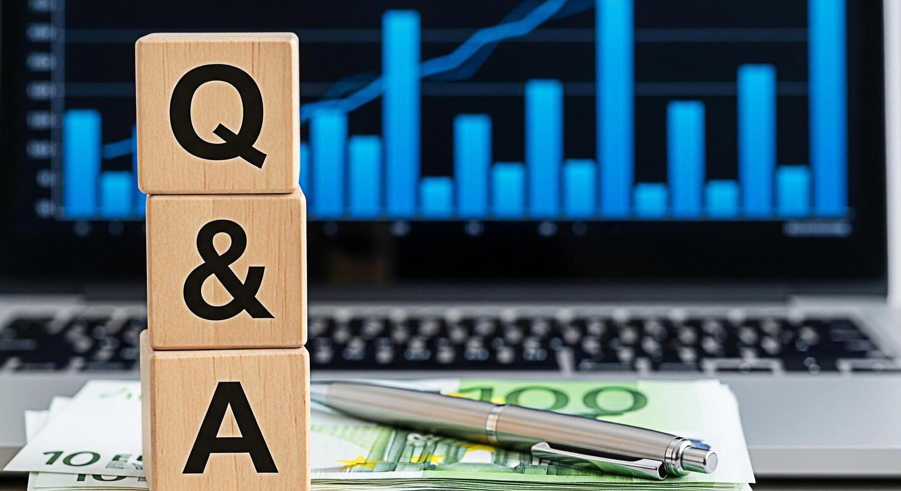 Wooden blocks displaying QA on a desk with a laptop showing financial charts symbolizing business consultation and knowledge sharing in a corporate environment fostering clarity and informed decisionm photo