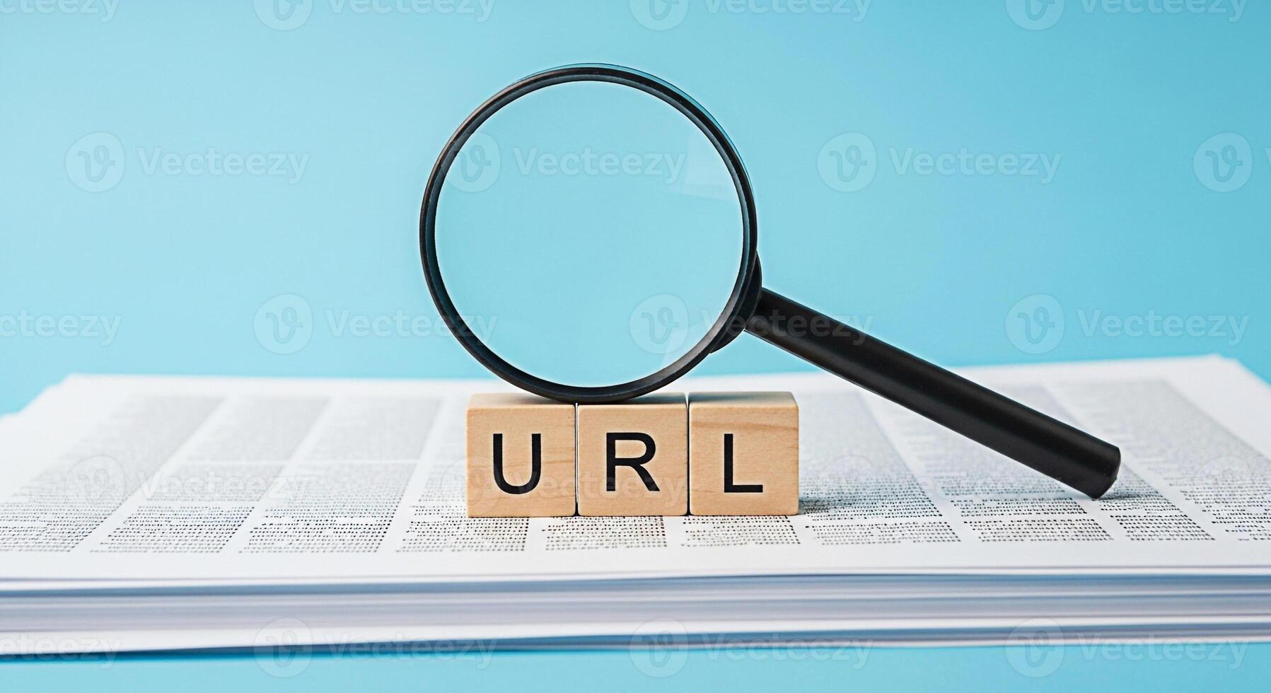 Magnifying glass inspecting URL wooden blocks on a stack of documents against a blue background symbolizing website analysis and search engine optimization for online visibility and information discov photo