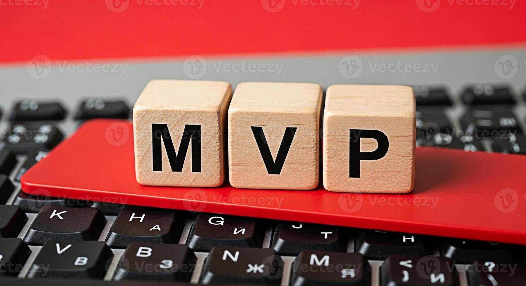 Wooden blocks spelling MVP resting on a red card atop a black laptop keyboard symbolizing a minimum viable product in a tech startup environment conveying innovation and agile development photo