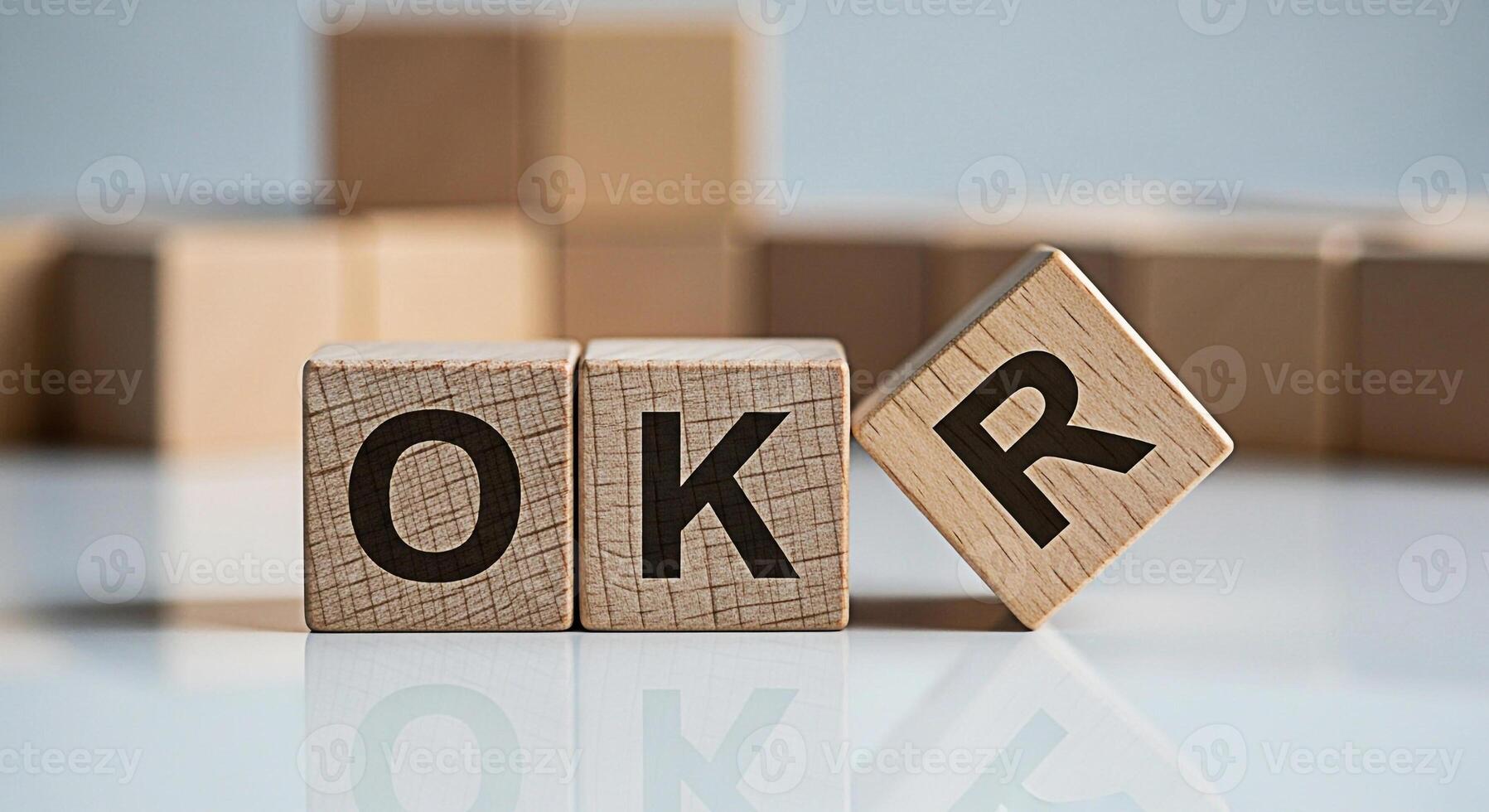 Wooden blocks displaying OKR acronym on a reflective surface representing objectives and key results in a business setting symbolizing goal setting and strategic planning for success photo