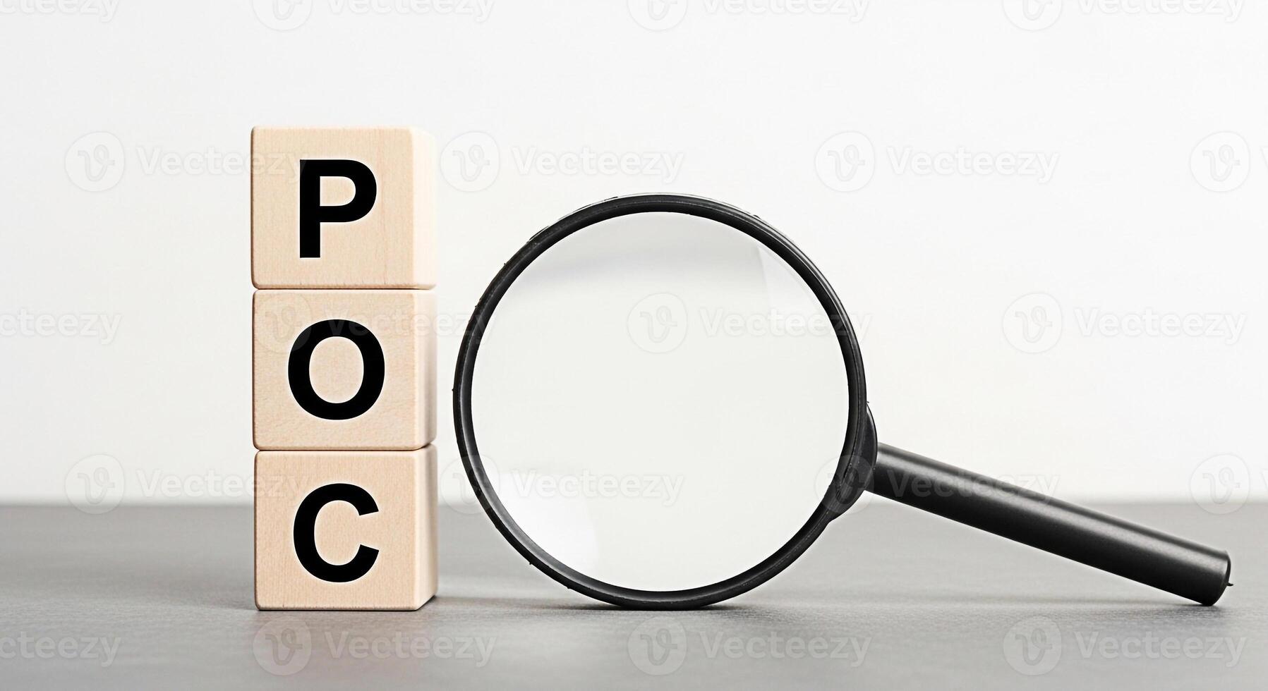 Magnifying glass inspecting wooden blocks spelling POC on a gray surface against a white background symbolizing proof of concept and the importance of thorough examination and validation in business a photo