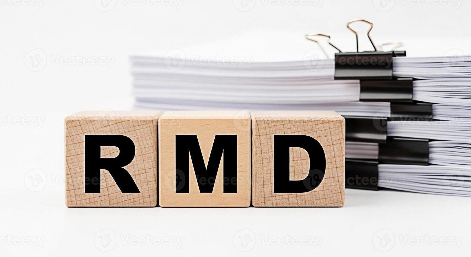 Wooden blocks displaying the letters RMD in a bright studio setting representing required minimum distributions and retirement planning with a focus on financial responsibility and future security photo