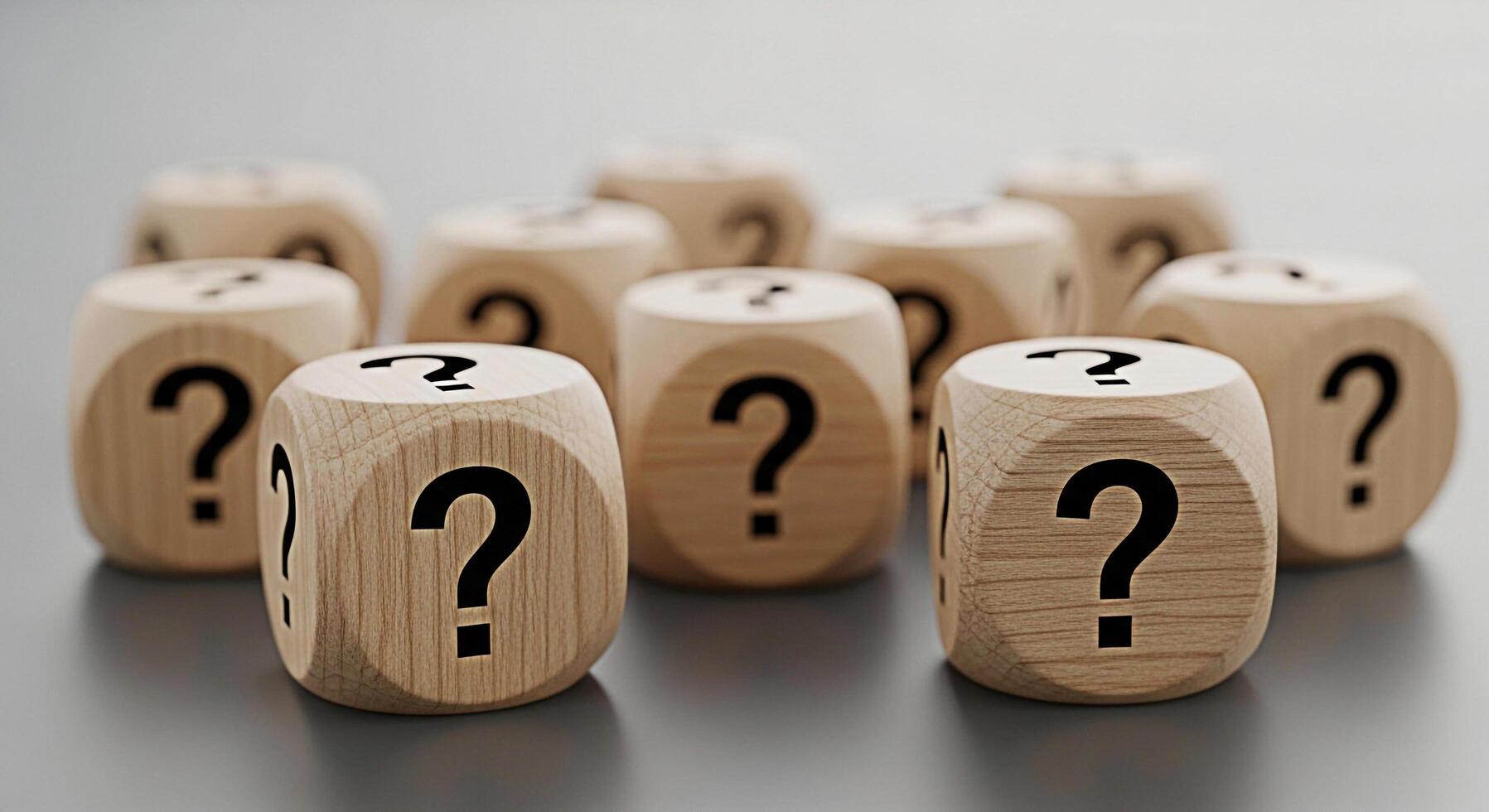 Wooden question mark cubes scattered on a gray surface representing uncertainty and the need for answers in business education and personal life creating a mood of curiosity and inquiry photo