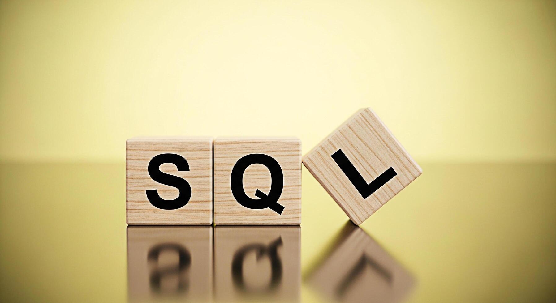 Wooden blocks spelling SQL on a reflective surface against a golden background representing database management and structured query language concepts with a clean and professional aesthetic photo