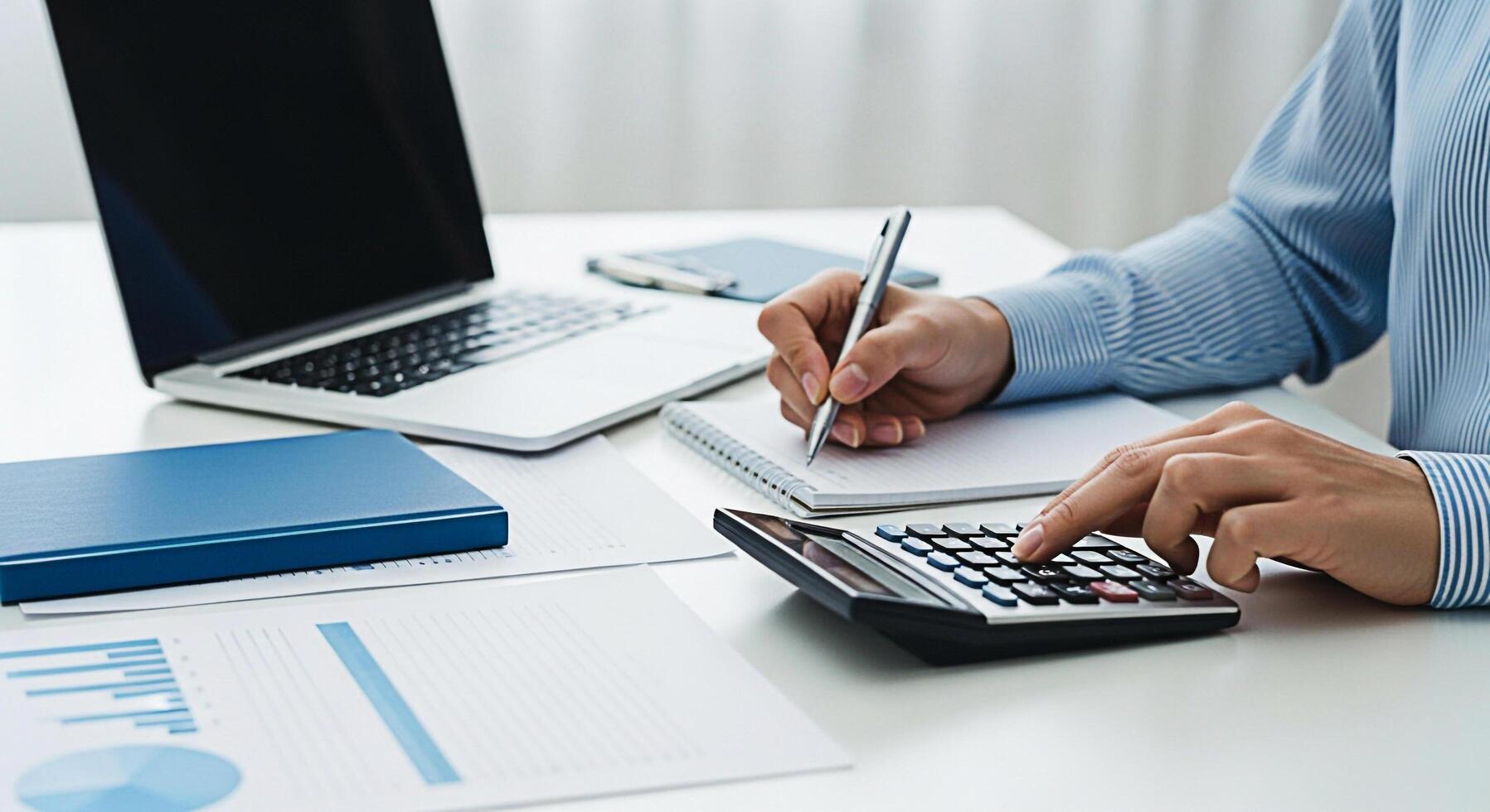 A man is using a calculator and pen to write on a paper photo