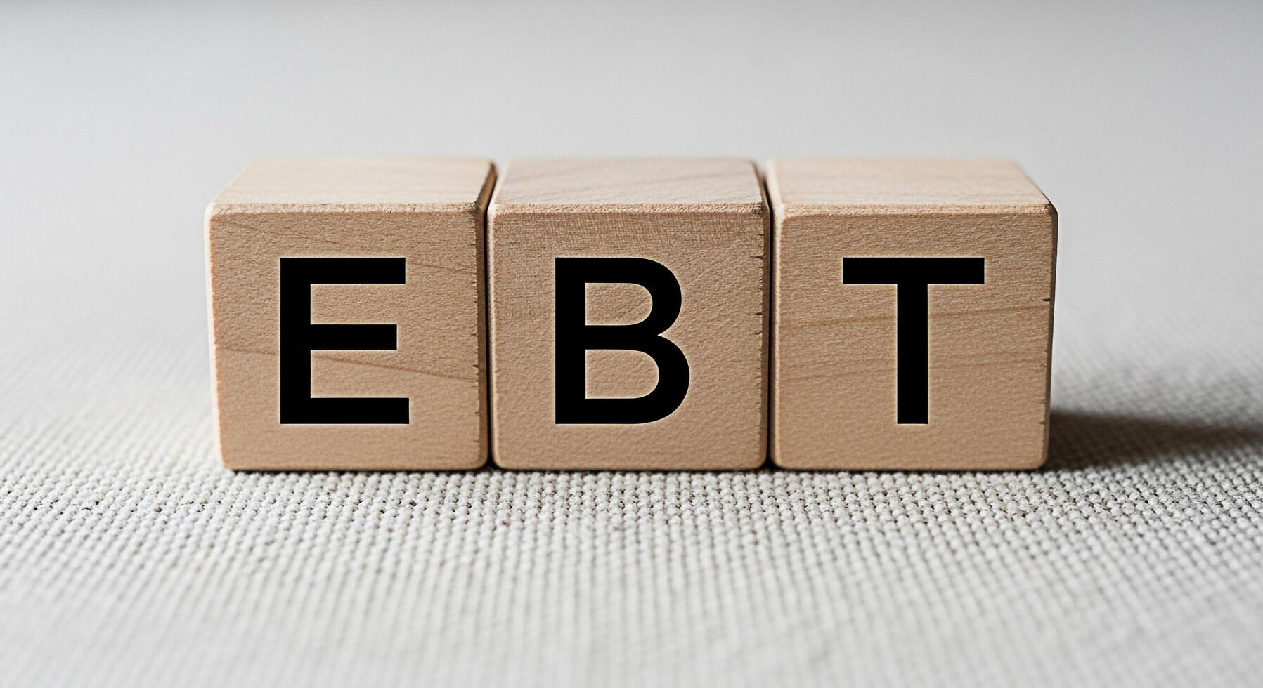 Wooden blocks spelling EBT on a textured surface representing government assistance and food security conveying a message of support and access to essential resources in a macro studio shot photo