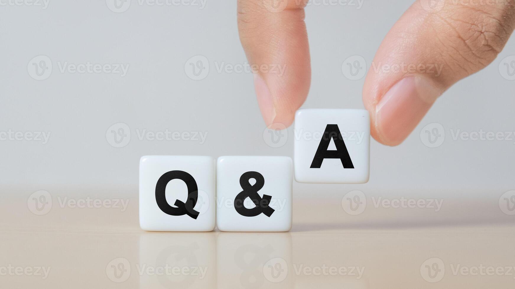 Hand holding Q and A word with dice cube. FAQ frequency asked questions, Answer, Question Ask, Information, Communication and Brainstorming Concepts photo