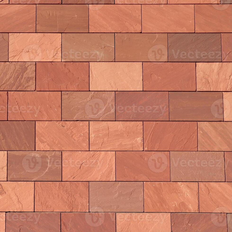Abstract full frame closeup of a wall of brown, terracotta-colored, and reddish rectangular bricks, showcasing their varied textures and hues in a precise, geometric pattern. photo