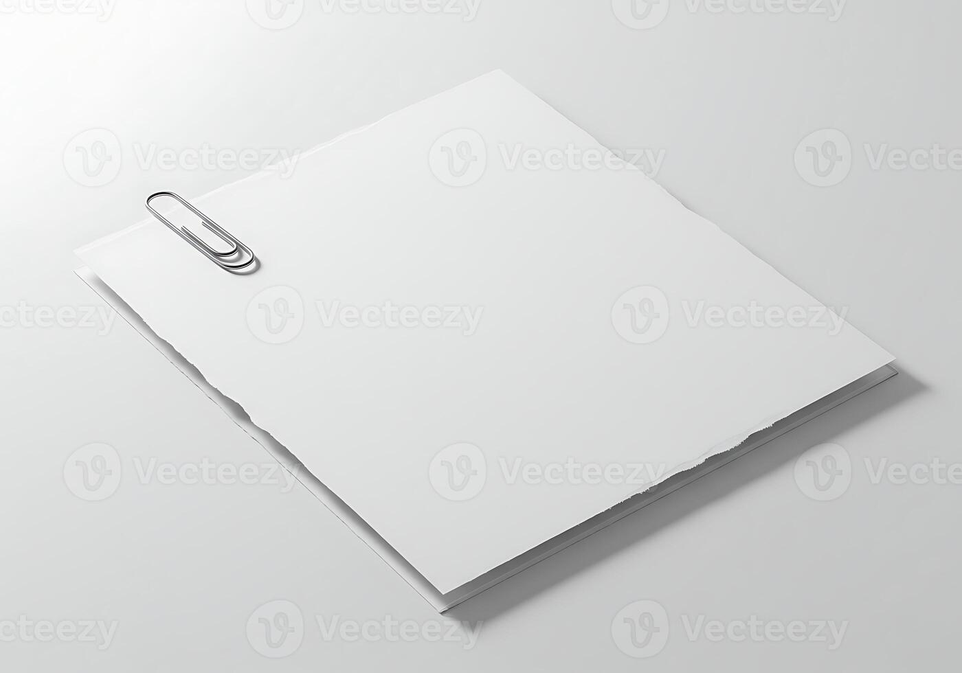 Minimalist composition featuring blank white paper sheets fastened with a metal paperclip on a bright, uncluttered background for various design photo