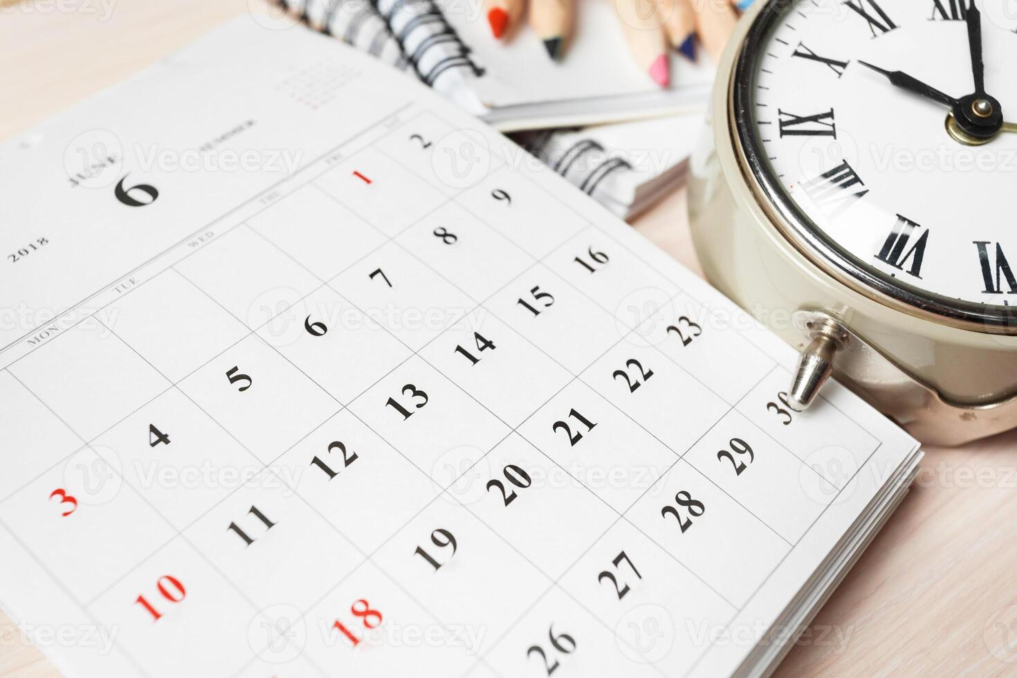 Calendar and clock on a workspace showing the date and time for organizing daily tasks photo