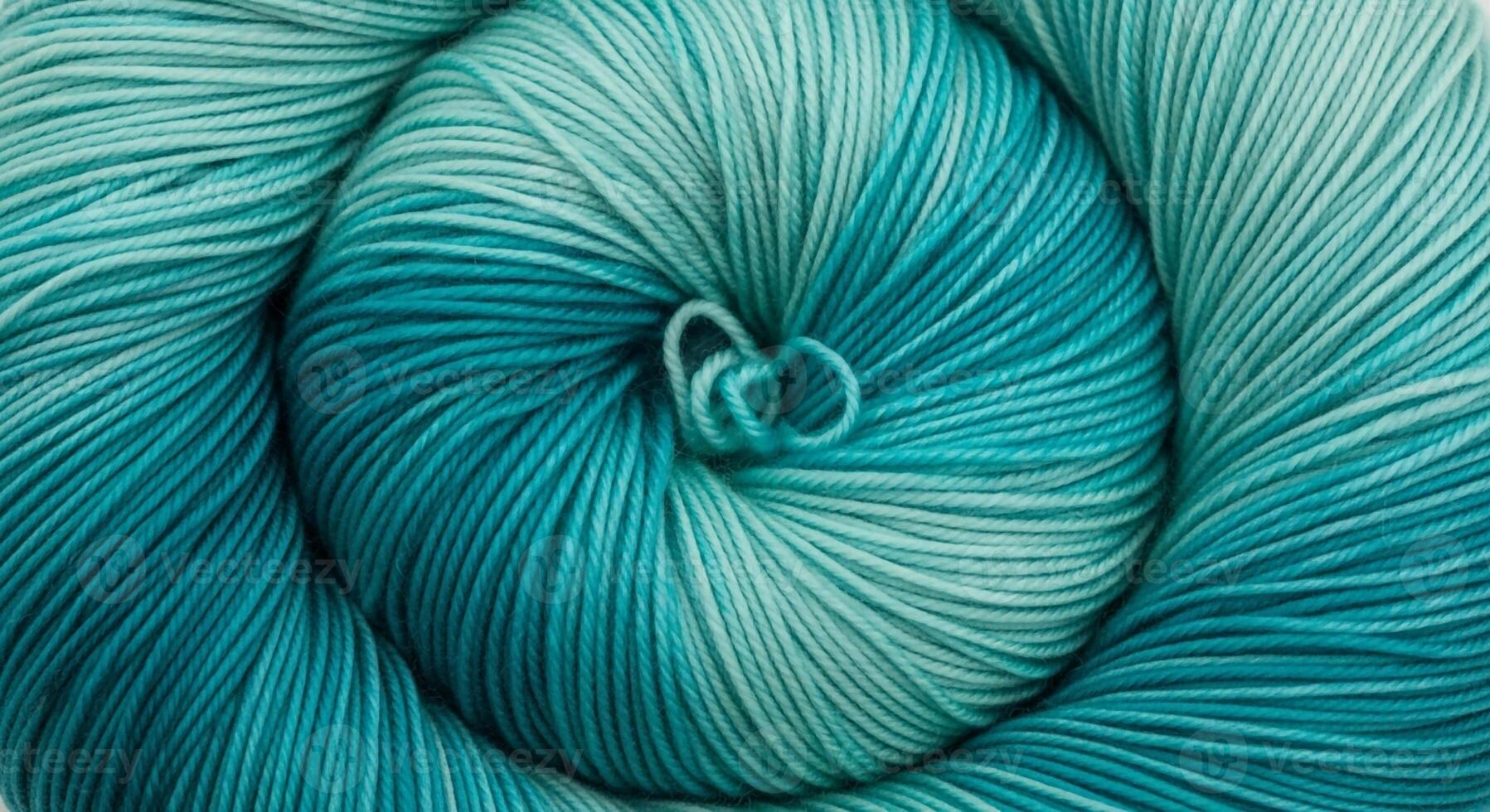 Close up view of a tightly wound skein of variegated teal and aqua yarn showcasing its soft texture and subtle color transitions photo