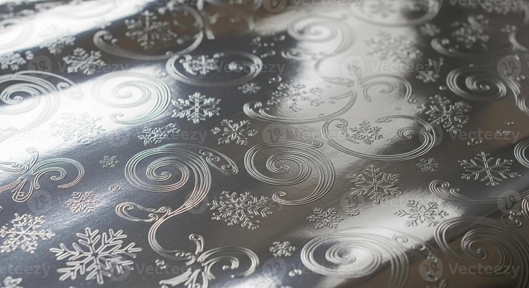 Close up view of a textured surface with embossed swirling patterns and delicate snowflake motifs in a cool reflective tone photo