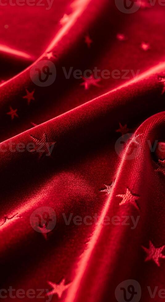 Luxurious deep red fabric draped with subtle star pattern and gleaming highlights photo