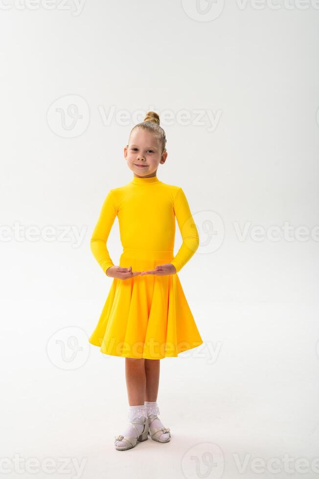 Smiling child in bright yellow practicing choreography with hearing device. Confidence, concentration, and harmony of movement despite deafness, showing inclusion photo