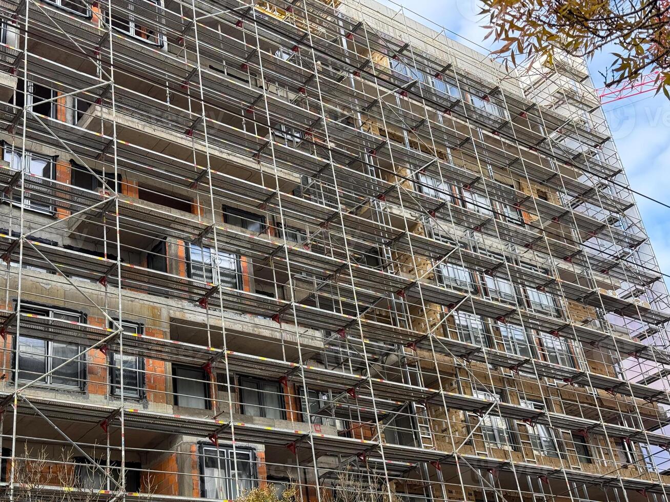 Scaffolding pattern on facade of urban construction site. Engineering precision, geometry and transformation in architectural development. photo