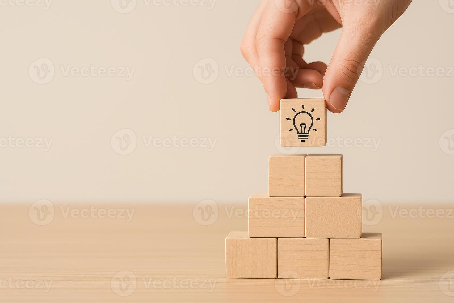 Hand placing wooden block with light bulb icon on top of pyramid blocks symbolizing 2026 planning roadmap and idea development for future success and innovation photo