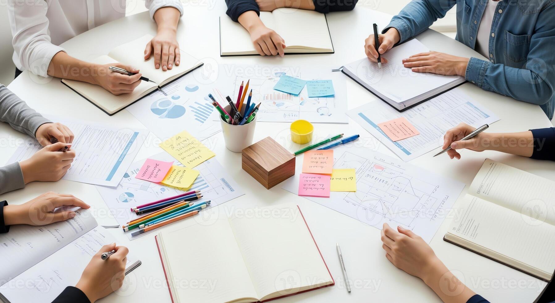 Team collaborating and brainstorming ideas around a circular table with documents photo