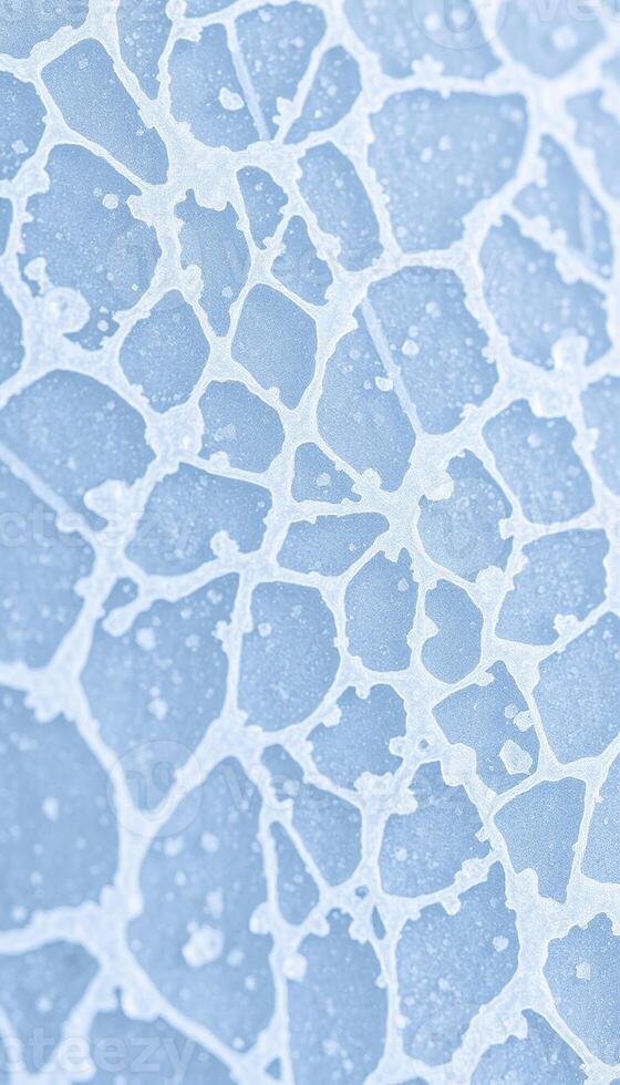 Macro view of a shattered blue ice surface showing intricate crack patterns and crystalline shards photo