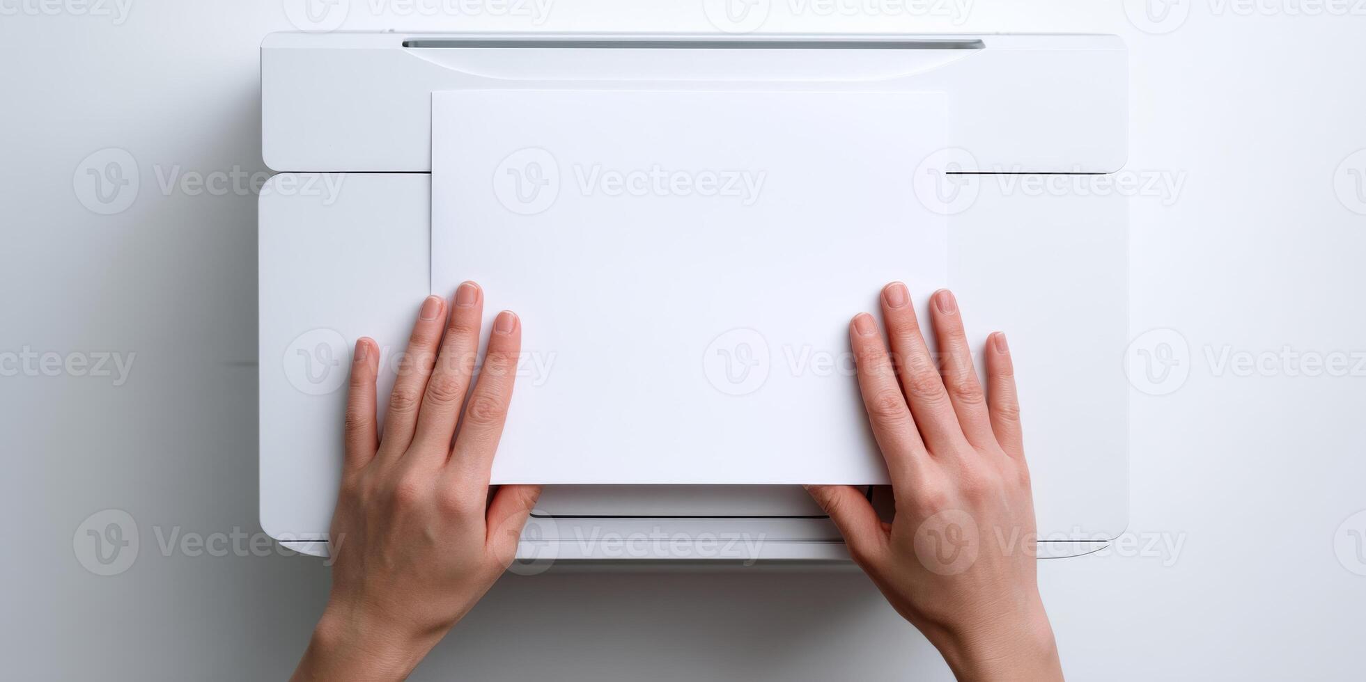 Hands loading blank paper into printer from above photo
