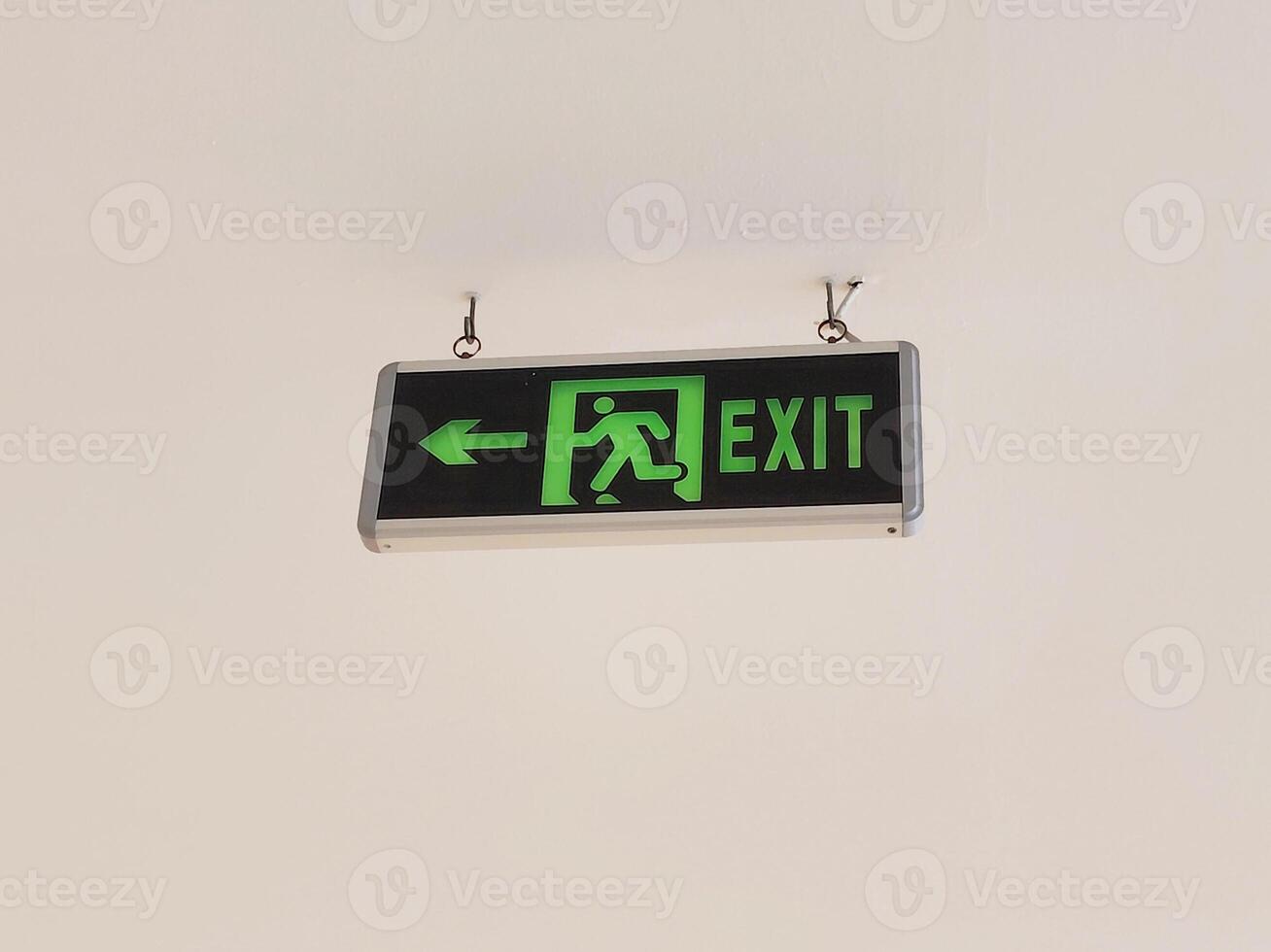 Illuminated Emergency Exit Sign with Running Man Symbol and Directional Left Arrow photo