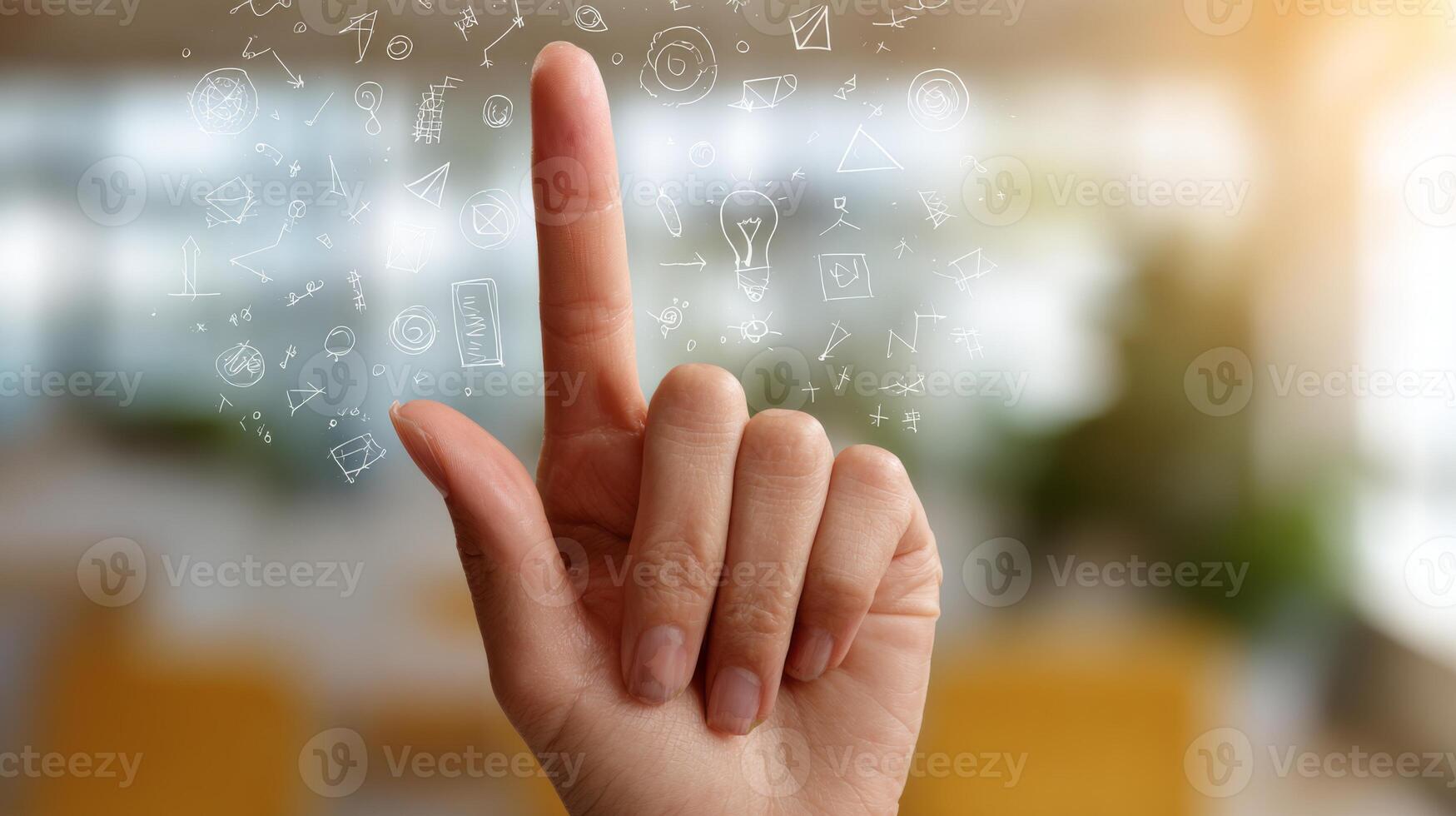 A human hand with extended index finger pointing upwards, surrounded by creative icons and symbols in a bright, modern workspace. photo